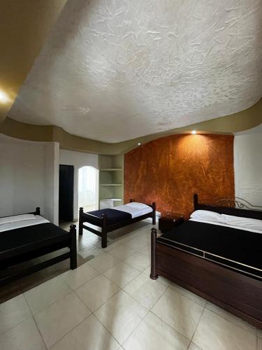 a large room with two beds and a ceiling at mansion cafetera in Quimbaya