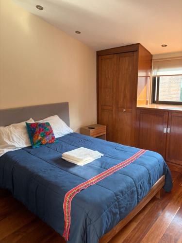 a bedroom with a bed with a blue blanket at Casa Coyoacan in Mexico City