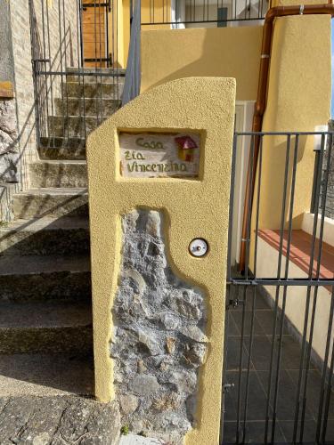 a sign on a wall next to a staircase at Casa zia Vincenzina in Casalvecchio Siculo