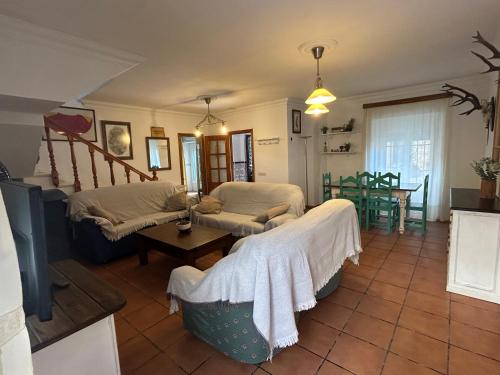a living room with two beds and a table at La Casa Grande in Benaocaz