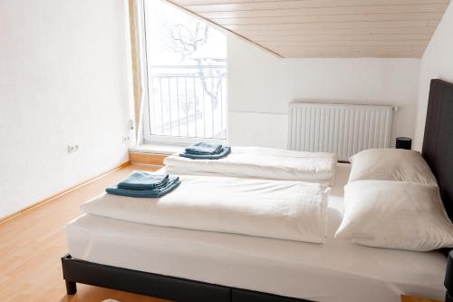 two white beds in a room with a window at Haus Treff in Weissenbach am Lech