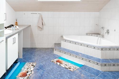 a bathroom with a tub and some shells on the floor at Haus Treff in Weissenbach am Lech