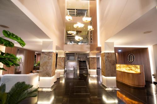 a lobby of a hotel with white chairs and a staircase at Zi One Luxury Hotel in Pereira