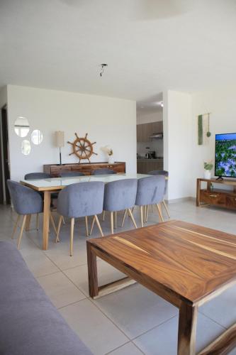 a dining room with a table and blue chairs at Escapada familiar, departamento para 8 con Club de Playa incluido in Acapulco