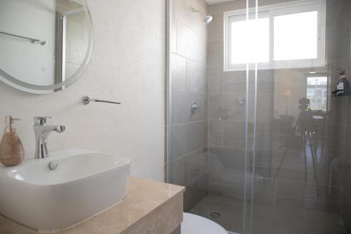 a bathroom with a sink and a glass shower at Escapada familiar, departamento para 8 con Club de Playa incluido in Acapulco