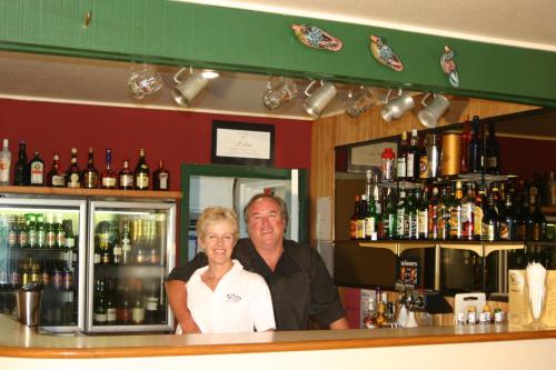 a man and a woman standing behind a bar at Mt Hutt Lodge in Windwhistle
