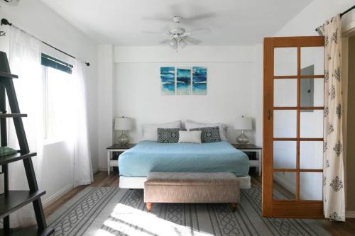 a bedroom with a blue bed and a window at North Shore Bungalow in Mokuleia