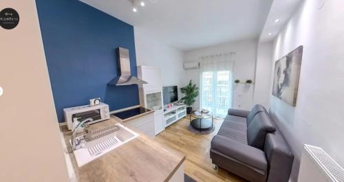 a living room with a couch and a blue wall at NAVA Apartment in the center with private parking of stayinthess in Thessaloniki