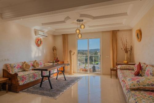 a living room with a table and a couch at appartement chaleureux essaouira in Essaouira