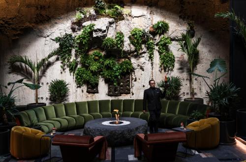 a man standing in a room with a green couch at Volga, Member of Preferred Hotels & Resorts in Mexico City