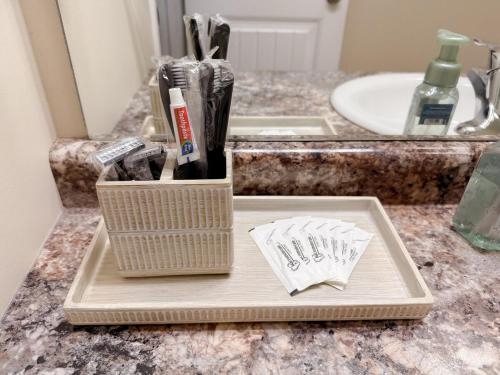 a bathroom counter with a tray with toothbrushes and a sink at Spacious 4BR with King Suite - Garage - Netflix in Lloydminster