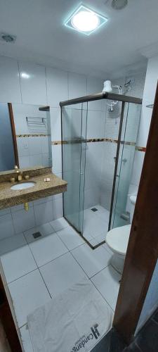 a bathroom with a glass shower and a toilet at Candango Aero Hotel in Brasília