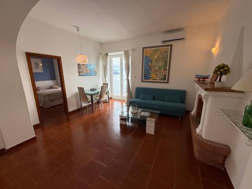 a living room with a blue couch and a table at Maison Raphael Positano in Positano