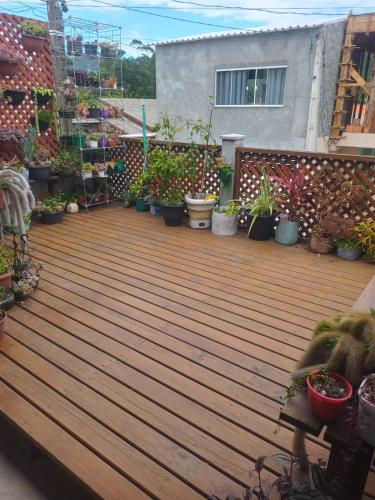 a wooden deck with potted plants on a house at Casa Flores do Campo in Florianópolis