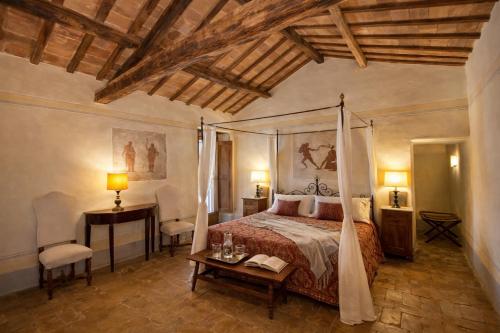 a bedroom with a bed and a table and chairs at VesConte Residenza D'epoca dal 1533 in Bolsena