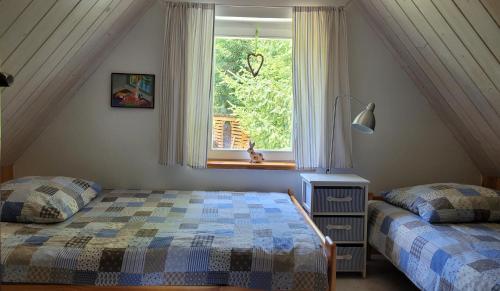 a bedroom with two beds and a window at Domek Klimaty- Kamieńczyk in Międzylesie