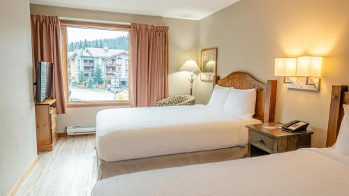 a hotel room with two beds and a window at Cahilty #212 home in Sun Peaks