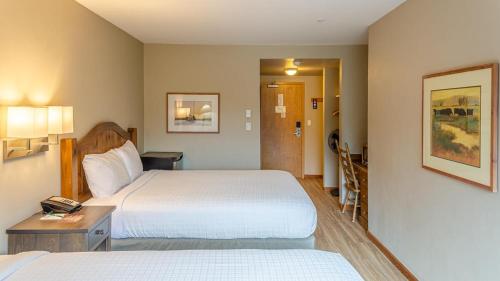a hotel room with two beds and a hallway at Cahilty #212 home in Sun Peaks