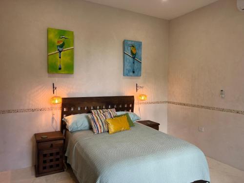 ein Schlafzimmer mit einem Bett und zwei Gemälden an der Wand in der Unterkunft El Oasis in Chelem