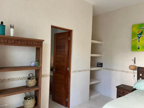 ein Schlafzimmer mit einem Bett, einer Holztür und Regalen in der Unterkunft El Oasis in Chelem