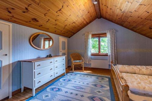 a bedroom with a bed and a dresser and a mirror at KRO863-Virestad-Stubbalycke-4 in Virestad