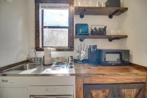 eine Küche mit Spüle und Mikrowelle in der Unterkunft Rustic Ridge in Gentry