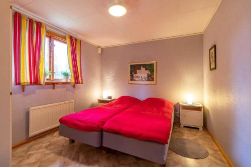 a bedroom with a red bed in a room at KRO891-Hallaryd-Kalvshult-8 in Hallaryd