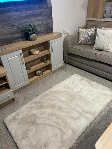a living room with a couch and a rug at Dollys Den in Pagham
