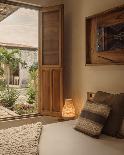 a bedroom with a bed and a large window at Campeche Mágico in Campeche