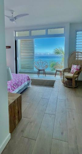 a bedroom with a bed and a view of the ocean at White Sand Villa - infinity pool in Paea