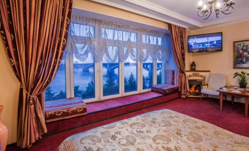 a bedroom with a bed and large windows at Гостиница Огни Енисея in Krasnoyarsk