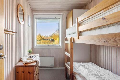 a small bedroom with bunk beds and a window at LL261-Humble-Gyvelvaenget-1 in Spodsbjerg