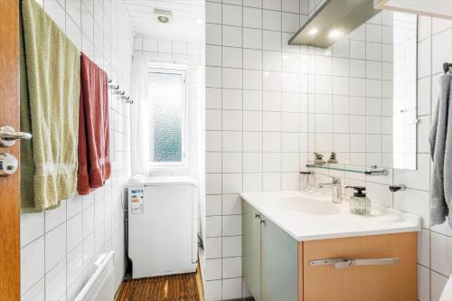 a white bathroom with a sink and a refrigerator at LL261-Humble-Gyvelvaenget-1 in Spodsbjerg