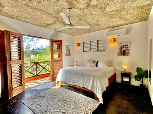 a bedroom with a bed and a balcony at Hostal Luz Del Valle in Santa Bárbara de Samaná