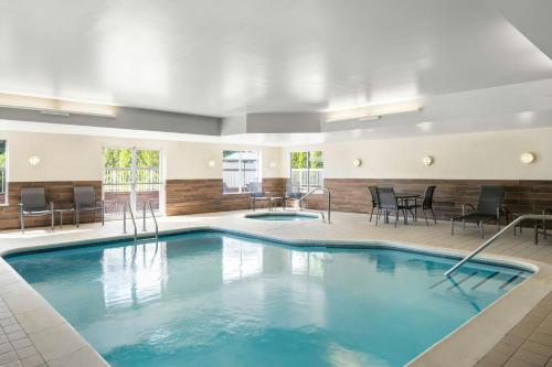 a pool in a hotel room with chairs and tables at Fairfield Inn and Suites by Marriott Marion in Marion