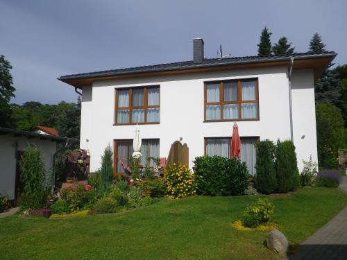 a white house with a garden in front of it at Ferienwohnungen Stranddistel - Apartments von 30 bis 75 qm in Zinnowitz