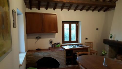 a kitchen with a brick fireplace and a table and a window at Il Merangolo in Montebuono