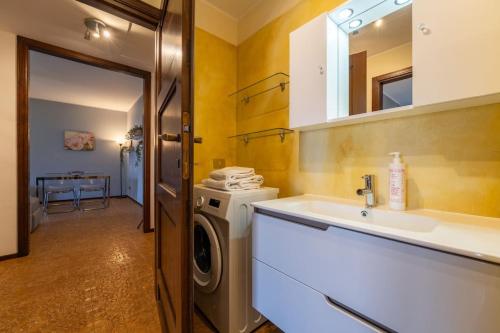 a bathroom with a sink and a washing machine at Ca Maria Peonie Apartment in Bellagio
