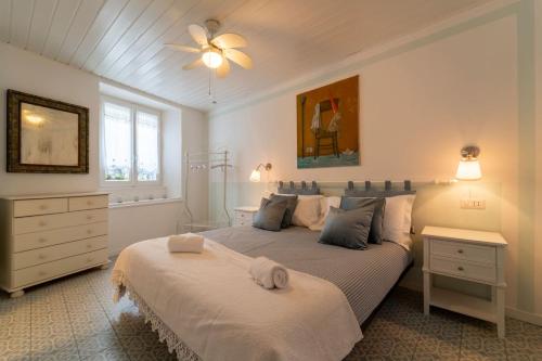 a bedroom with two beds and a ceiling fan at Loving Loppia - Glicine in Bellagio