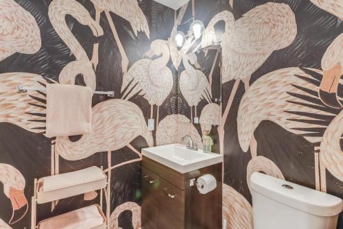 a bathroom with a wall mural of flamingos at The Tropical Cottage in Long Beach