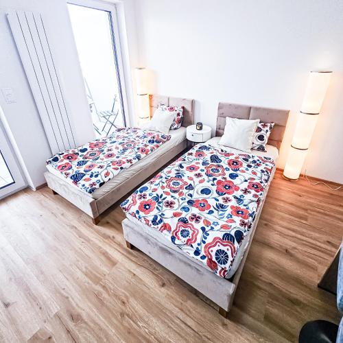 a bedroom with two beds and a window at B-point apartments in Komárov