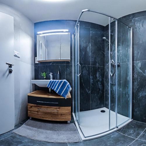 a bathroom with a shower and a sink at B-point apartments in Komárov