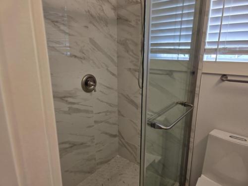 a shower with a glass door in a bathroom at Modern Victorian by Beach and Forest Unit B in Crescent City