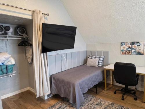 a bedroom with a bed and a flat screen tv at Modern Victorian by Beach and Forest Unit C in Crescent City