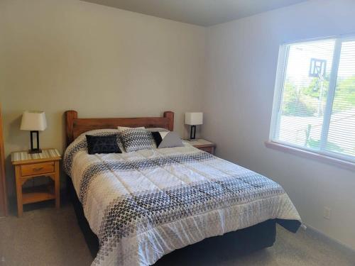a bedroom with a bed and two lamps and a window at The Hofer Beach Retreat in Crescent City