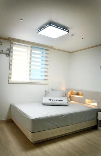 a bedroom with a large white bed with a window at 24 Guesthouse Suncheon in Suncheon