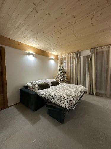 a bedroom with a bed and a christmas tree at Maison ValGià in Champoluc