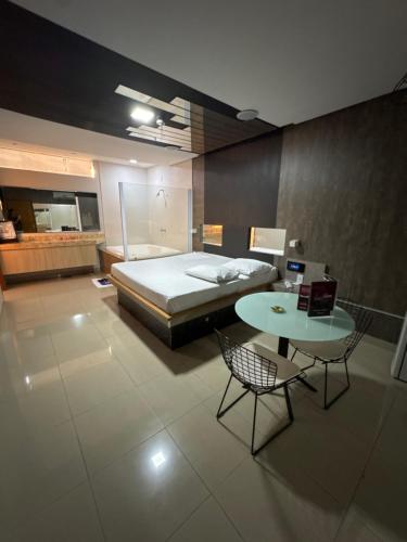 a bedroom with a bed and a table and a table and chairs at Motel Canadá moto gp in Senador Canedo