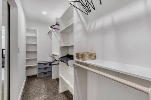 a walk in closet with white walls and shelves at 4BR Mesa Basecamp, Mins to Cubs Spring Training in Mesa