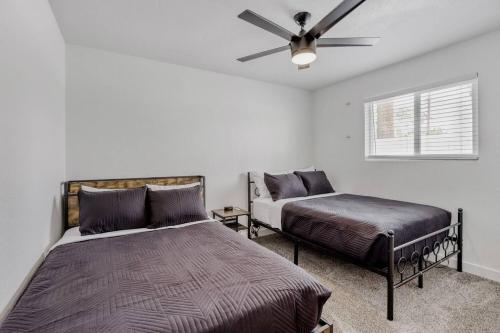 a bedroom with two beds and a ceiling fan at 4BR Mesa Basecamp, Mins to Cubs Spring Training in Mesa